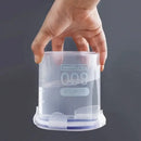 A hand holds the Lovely Home Icon Plastic Sealed Tank Large Capacity Crisper Kitchen Organize Grain Storage Box with Scale, an 800 ml clear spice container, filled with water and displayed upside down without leaking against a plain gray background.