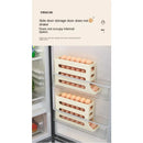 Two beige plastic Lovely Home Icon Refrigerator Egg Storage Boxes, each featuring 4 layers with an automatic rolling design, are attached to the inside of a refrigerator door. These kitchen organizers efficiently store eggs, save space, and prevent the eggs from shaking inside your fridge.