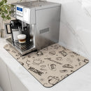 A silver espresso machine on a counter brews a cappuccino. Underneath, the Coffee Machine Mat by Lovely Home Icon—featuring rubber backing and water-absorbent fabric—shows off coffee-themed illustrations like cups, beans, croissants, and words such as “Welcome” and “Enjoy Fresh.” This beige kitchen worktop mat adds both modern style and functionality to your home decor.