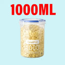 A clear Plastic Sealed Tank Large Capacity Crisper Kitchen Organize Grain Storage Box with Scale Sealed Box Clear Jar Spice Container by Lovely Home Icon, filled with yellow cereal flakes, is shown on a light blue background. The airtight container is labeled and features “1000ML” in large red text above it.