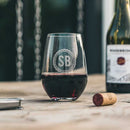 Stemless wine glass engraved with the initials SB inside a circular border, sitting on a wooden surface next to a wine cork and a Wine Decanter - The Diamond by Swanky Badger.