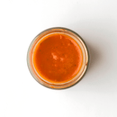 A glass jar of Famiglia Crispino Green Olive Pasta Sauce — Ready-Made Italian Sugo by Taycte, viewed from above, sits on a white background.