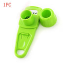 A green plastic kitchen tool from Lovely Home Icon, labeled “1PCS” in red at the top left corner, featuring a handle, blade, and two circular attachments. This multi-functional manual gadget can be used as a garlic crusher, ginger grater, garlic peeler, or cutter.