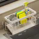 The Lovely Home Icon Sponge Draining Rack – Dishcloth & Dishwashing Liquid Storage Kitchen Organizer is shown on a counter, holding a spray bottle, two yellow-green sponges, a steel scrubber, and a small brush. With its waterproof design and dimensions of 23cm x 9cm x 11cm, this versatile organizer is perfect for multiple kitchen uses.