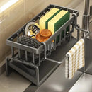 The Lovely Home Icon Multifunctional Sponge Draining Rack—designed for kitchen cloths, dishwashing liquid, and cleaning essentials—holds sponges, scrubbers, and a small dish brush in its waterproof metal frame. A striped dish towel hangs neatly on the side. The organizer sits conveniently beside the sink on your countertop, providing accessible storage racks for tidy kitchen organization.
