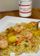 A white plate features seasoned rice with grilled shrimp and pineapple, paired with a bottle of Terrapin Ridge Farms Tropical Tequila sauce in the background for a vibrant burst of pineapple, mango, and coconut flavor.