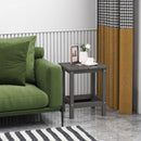 A green couch sits beside the DirectDeals Square Adirondack Side Table 14″ Weather-Resistant HDPE, topped with a white rose in a vase, two framed photos, and a white tea set. Yellow and black curtains frame the window; a striped rug lies below.