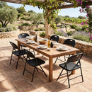 A wooden patio table set for six is surrounded by DirectDeals Foldable Plastic Dining Chairs Set of 6 with Ergonomic Backrest; plates and condiments are displayed, with gardens and vineyards in the background.
