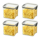 Four clear, square Lovely Home Icon 1-4PCS Sealed Jars Kitchen Organizer Grain Storage Boxes with black locking lids, each filled with yellow cornflakes, are arranged in a grid pattern on a white background.
