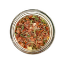 A glass jar of SALTOPIA Infused Sea Salts’ SHE DEVIL Spicy Herbal Blend, featuring Pink Himalayan sea salt, dried herbs, and spices, viewed from above against a white background.