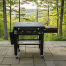 The BBQ Boards® 30" Blackstone Griddle Side Cutting Board sits on a stone patio with trees and a scenic forested backdrop—ideal for flat top prep or as your go-to BBQ cutting board station.
