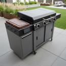 A modern outdoor gas grill with four burners features the BBQ Boards® 36" Blackstone Griddle Side Cutting Board and a digital control panel, set on a patio with green grass and landscaped plants in the background.