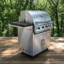A stainless steel Blaze Grills LTE gas grill with four burners and closed storage stands on a wooden deck, featuring a BBQ Boards® Blaze Grills LTE or LTE+ Side Cutting Board, with green trees in the background.