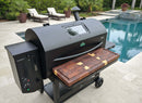 A BBQ Boards® GMG Peak Prime 2.0 Front Cutting Board adds generous prep space to a large black pellet grill on a tiled poolside patio, complemented by lounge chairs, potted plants, and Green Mountain Grills accessories for a stylish setup.