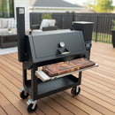 A BBQ Boards® Lone Star Grillz 20" x 42" Front Cutting Board by BBQ Boards® sits atop a black outdoor pellet smoker grill with a built-in thermometer, ideal for prepping BBQ and organizing pellet smoker accessories on the deck.