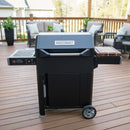 A BBQ Boards® Masterbuilt AutoIgnite Series 545 Side Cutting Board is set up on a patio deck, offering convenient grill-side prep space and surrounded by outdoor furniture and potted plants.