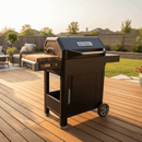 A BBQ Boards® Masterbuilt AutoIgnite Series 545 Side Cutting Board is attached to a black grill with side shelves and wheels, positioned on a wooden deck in a sunny backyard with patio furniture, grass, and a fence in the background.