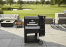 A BBQ Boards® Masterbuilt Gravity Series 800 Side Cutting Board sits on a patio beside outdoor seating, overlooking a scenic golf course—ideal for refining your grill-side workflow or prepping food with this premium BBQ Boards® accessory.