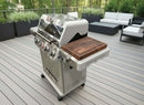 A BBQ Boards® Monument Grills Mesa 405BZ Side Cutting Board from BBQ Boards® sits on a modern gas grill on a spacious outdoor deck, surrounded by seating and lush greenery.