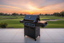 A BBQ Boards® Napoleon Prestige 500 Side Cutting Board is featured on a black outdoor grill set on a tiled patio overlooking a golf course at sunset, framed by vibrant skies and lush green fairways.
