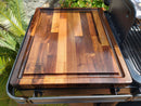 The BBQ Boards® Traeger Ironwood XL Side Cutting Board by BBQ Boards® shines outdoors on the grill’s side board, with its edge groove and stamped BBQ logo making it the ideal prep surface for any cookout.