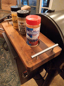 Three BBQ Boards® Traeger Pro 34 Front & Pellet Bin Cutting Boards hold Texas-themed Buckle Busters and two other barbecue rubs—an ideal addition for your indoor or patio grilling setup.