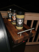 A pair of BBQ Boards® Traeger Pro 780 Front & Pellet Bin Cutting Boards by BBQ Boards® rest on a grill at night, with a wooden railing in the background—ideal for BBQ prep and complementing your favorite grill accessories.
