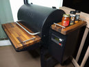 A Traeger wood pellet grill on a patio is shown with BBQ Boards® Traeger Pro 780 Front & Pellet Bin Cutting Boards (Pair), making it easy to organize accessories or create a handy BBQ prep station. Brand: BBQ Boards®.