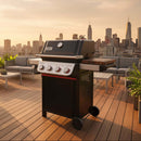 A BBQ Boards® Weber Spirit Reinvented Side Cutting Board is attached to a black and silver grill on a rooftop deck with lounge seating, overlooking the city skyline at sunset.