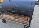 A black outdoor smoker grill with a closed lid, featuring BBQ Boards® Yoder YS1500 Front & Pellet Bin Cutting Boards (Pair) as a stylish prep station for organizing your BBQ Boards® accessories on the patio.