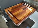 The BBQ Boards® Yoder YS480 or YS640 Side Cutting Board features a thick, rectangular two-tone checker pattern, metal handles, and an edge groove for catching juices—perfect as a BBQ prep surface on any countertop.