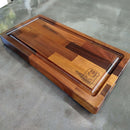 The Beast BBQ Board® 20" x 10" by BBQ Boards® is a rectangular cutting board featuring light and dark wood, a juice groove, and an engraved logo—perfect as a meat carving board.