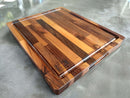 The Beastliest BBQ Board® 21" x 17" by BBQ Boards® features alternating light and dark wood strips, a juice groove, and a branded corner logo—ideal as a brisket carving board for your next barbecue.