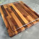 The Beastliest BBQ Board® 21" x 17" Cutting Board by BBQ Boards®—with rich brown tones, a juice groove, and logo branding—is the ideal brisket carving board for your next BBQ, displayed here on a gray countertop.