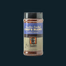 A container of Bourbon Barrel Foods Bourbon Smoked Chef's Blend all-purpose seasoning, with a blue and cream label, sits against a dark background.