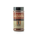 Bourbon Barrel Foods Bourbon Smoked Chili Powder comes in a plastic jar with a black cap and a brown, orange, and beige label featuring a bourbon barrel graphic. Made from New Mexico chili peppers for bold, smoky flavor.