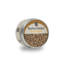 A slightly tilted round metal tin labeled "Bourbon Barrel Foods Bourbon Smoked Citrus Pepper" sits on a white background, filled with smoky citrus seasoning flecked with coarse pepper and yellow zest—ideal for adding flavor to grilled meats.
