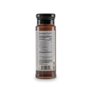 A glass bottle of Bourbon Barrel Foods Bourbon Smoked Sea Salt Caramel Sauce with a black cap is shown from the back, featuring the nutrition facts label and barcode, including serving size, calories, and other nutritional details.