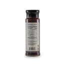 A glass bottle with a black lid displays the nutrition facts label for Bourbon Barrel Foods Chocolate Sauce – Bourbon Smoked Cacao Nibs & Bourbon in black text on a white background—ideal for gourmet dessert sauce enthusiasts.