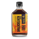 A bottle of Bourbon Barrel Foods Hot & Spicy Kentuckyaki™ boasts a bold yellow and orange label with flames, striking black text, and the phrase "Eat Your Bourbon.