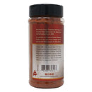 A reddish BBQ rub, Chicken Fried BBQ Texas Sweet Grind, comes in a bottle with a brown label featuring Bill Purvis, Grand Champion Pit Master of Chicken Fried BBQ; its sweet heat flavor is perfect for your next competition.