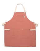 The Folded Steel Chef Apron, crafted from eco-friendly rPET canvas, features a rust color, cream straps, three front pockets—one subtly embroidered—and a small corner flower embroidery. Laid flat on a white background for sustainability and style.