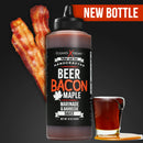 A bottle of Elijah's Xtreme Beer Bacon Maple BBQ Sauce by Elijah's Xtreme sits next to bacon strips and a glass of maple syrup on a black background. A red banner in the corner displays “NEW BOTTLE.”.