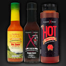 The Elijah's Xtreme Sweet & Heat Trio Hot Sauce Bundle, featuring three bold flavors, is showcased side by side against a dark background, ready to deliver the perfect balance of sweetness and heat.