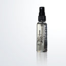 A transparent spray bottle labeled Folded Steel Knife Oil (2 oz) by Folded Steel, with an illustration of a hand holding a dagger. Filled with clear liquid, it's ideal for high carbon steel blade care and shown against a plain white background.
