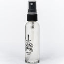 A 2oz clear spray bottle labeled Folded Steel Knife Oil by Folded Steel with a black spray top. Designed for high carbon steel blades, it shows a knife piercing a rose on the front over a plain white background.