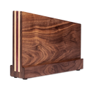 The Folded Steel Magnetic Knife Block by Folded Steel features alternating light and dark wood stripes, a smooth polished finish, magnetic knife storage, and stands upright on small rubber feet for an elegant display.