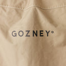 Close-up of the tan Gozney Dome Gen 2 Cover by Gozney, featuring bold black "GOZNEY°" lettering and white stitching for durability. This water-repellent oven cover provides lasting protection.