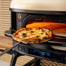 A freshly baked pizza with melted cheese and basil is being removed from a black Gozney pizza oven showing 468°F, briefly set on the Gozney Dome Gen 2 Mantel.