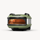 The Gozney Tread Portable Pizza Oven by Gozney is a compact, green and black outdoor oven with stainless steel accents, two handles on top, and a visible flame inside, shown against a plain white background.